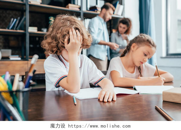 精疲力竭的小孩子在一起做作业学习压力无聊困扰无奈